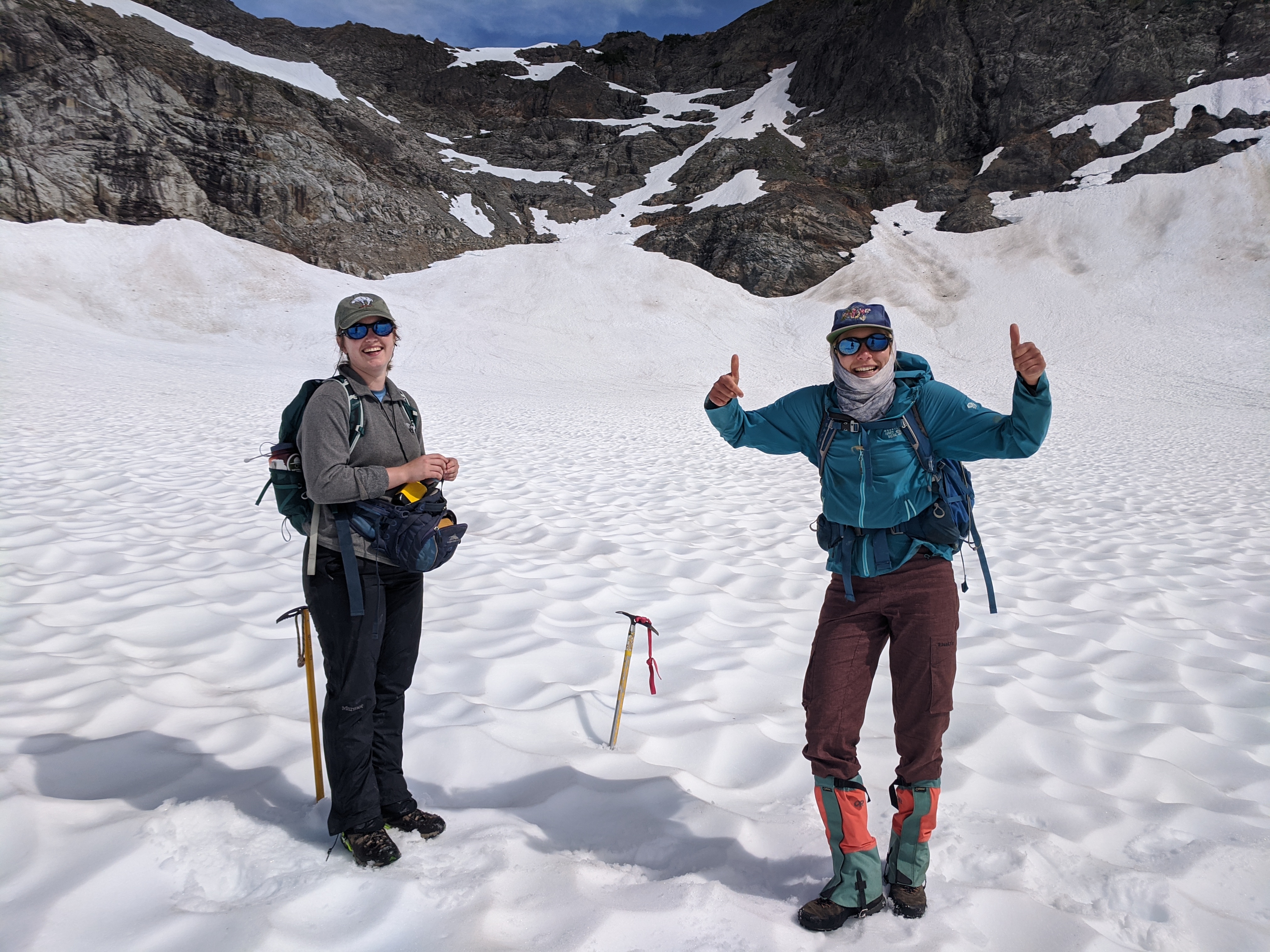 Two early career scientists celebrate a day of snowpack depth measurements on Columbia Glacier, North Cascades; Credit: Mariama Dryak