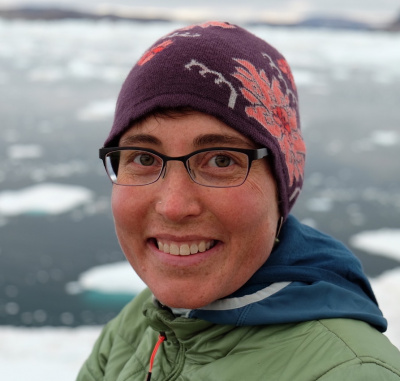 Twila Moon poses in front of a fjord in Greenland