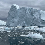 Stormy background with a large chunk of sea ice and water in the foreground