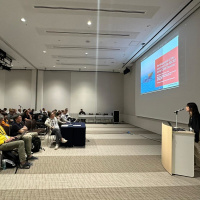 Yuka Nakato presenting their research to a large group of people at SPIE