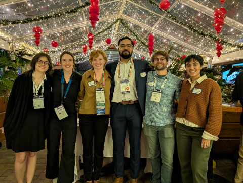Polar Early Career Researcher Social organizers pose for a photo at the Rusty Nail in front of a web of twinkle lights. Pictures left to right includes: Madison Payne, Mariama Dryák-Vallies, Ellie Miller, Mohammed Afzal Shadab, Benjamin Maglio, and Neosha Narayanan. 