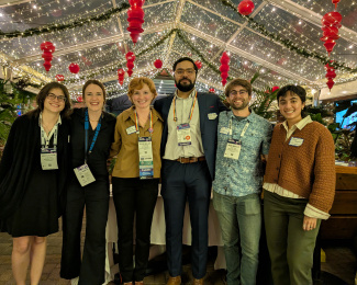 Polar Early Career Researcher Social organizers pose for a photo at the Rusty Nail in front of a web of twinkle lights. Pictures left to right includes: Madison Payne, Mariama Dryák-Vallies, Ellie Miller, Mohammed Afzal Shadab, Benjamin Maglio, and Neosha Narayanan. 