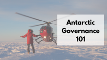 the text 'Antarctic Governance 101' overlain on top of an image of a person wearing a red coat guiding a red helicopter down to land on the ice in Antarctica