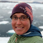 Twila Moon poses in front of a fjord in Greenland