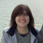 Madison Payne smiles at the camera, with water in the background